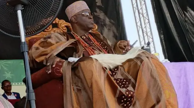 Soun tilẹ̀ Ogbomoso, ọba Ghandi Afolabi Laoye joko sori aga ọlọ́lá, ó wọ aṣọ oke agbada àti Sokoto aláwọ̀ Goolu pẹlu fìlà rẹ, o wa ìlẹ̀kẹ̀ sọrun, ó sì dé adé sórí.