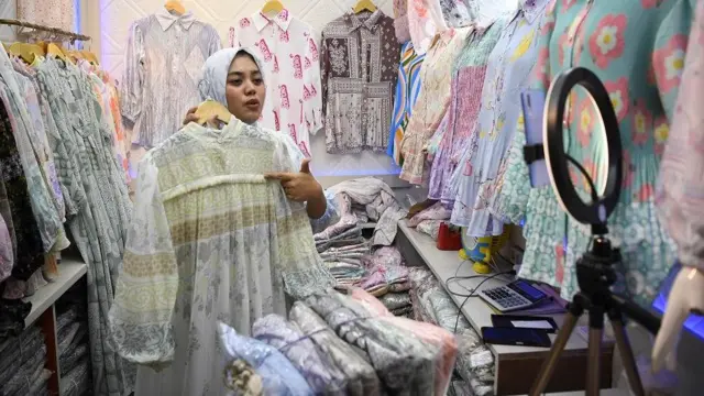 Seorang pedagang menawarkan dagangannya secara daring melalui media sosial di Pasar Tanah Abang, Jakarta, Selasa (19/9/2023).