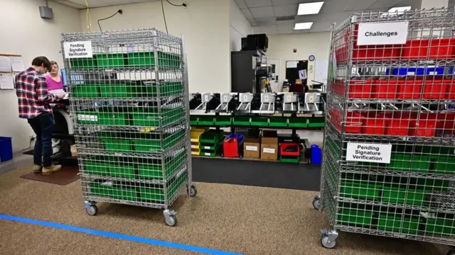 Trays of ballots that have been challenged or require signature verification at a ballot processing site in California