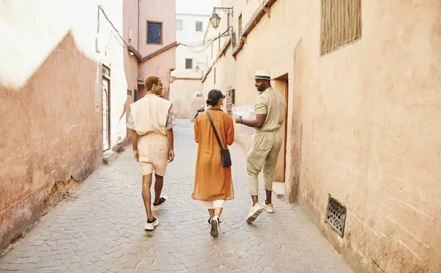 Des personnes déambulent dans une ruelle étroite de la médina de Marrakech, au Maroc.