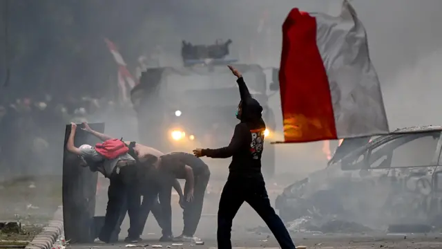 Pengunjuk rasa melakukan aksi di depan Markas Komando Brimob Polda Metro Jaya, Kwitang, Jakarta, Jumat (29/8/2025). 