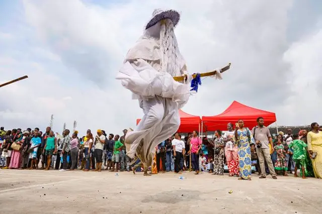 Participants for di traditional Eyo Festival, dem wear white garments, wide-hat and dem carry wooden staff known as Opambata, as crowds gada to celebrate di cultural heritage and history of Lagos for Lagos, Nigeria,