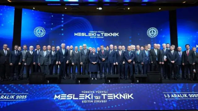 Tekin orada, onlarda takım elbiseli yetkiliyle sahneden, alt tarafta Mesleki ve Teknik Eğitim zirvesi yazıyor.