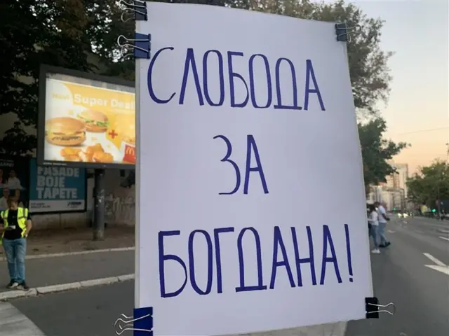 Plakat na kojem piše ćirilicom i plavim slovima na belom papiru "Sloboda za Bogdana"