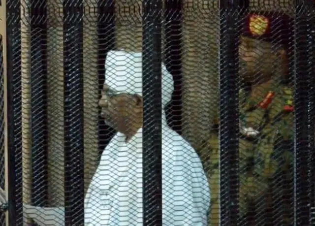 عمر البشیر، رئیس جمهور سابق سودان پس از برکناری در جایگاه متهم در داخل دادگاهی در سودان