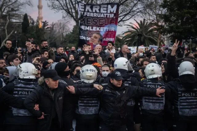 Полиция сдерживает протестующих, чтобы пожарные машины могли проехать по улице во время марша протеста в поддержку арестованного мэра Стамбула Экрема Имамоглу