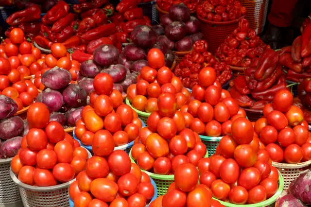 Une pile de tomates, d'oignons et de poivrons