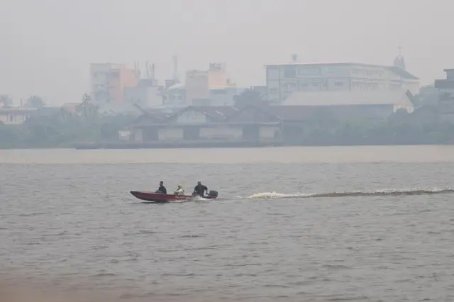 Perahu motor bermuatan penumpang melintasi Sungai Kapuas yang diselimuti kabut asap di Pontianak, Kalimantan Barat, Minggu (23/08).