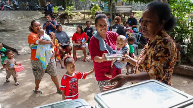 Keluarga penerima manfaat antre mendapatkan Makan Bergizi Gratis (MBG) di Posyandu Roudi Manokwari, Papua Barat, Senin (12/1/2026).