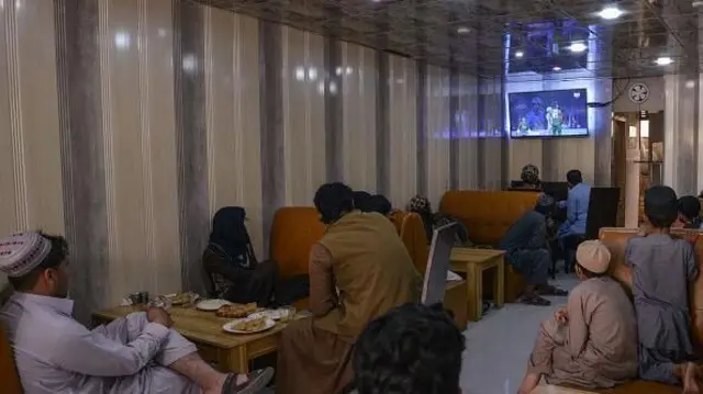 افغانان په یوه هوټل کې پر ټلویزیون د کرېکټ لوبه ګوري
