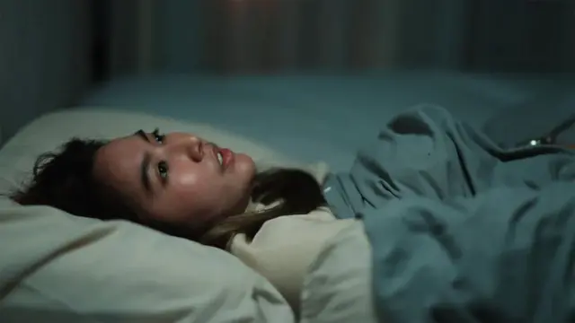 жена лежи у кревету отворених очију 