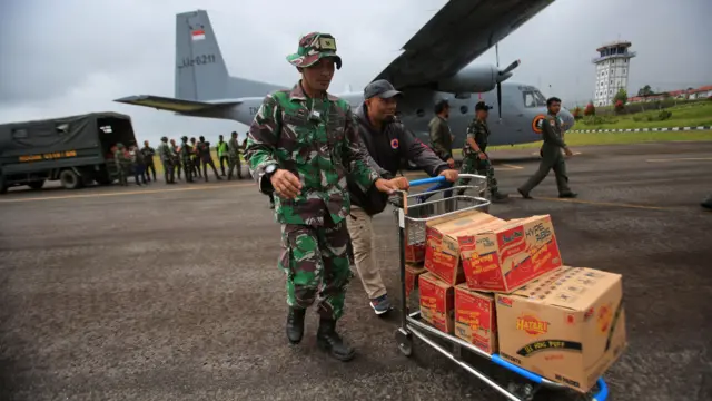 Petugas menurunkan logistik bencana dari pesawat Cassa U-6211 saat tiba di daerah wilayah terisolir Bandara Rembele, Kabupaten Bener Meriah, Aceh, Selasa (2/12/2025).