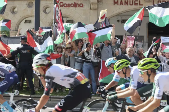 يتظاهر الناس حاملين الأعلام الفلسطينية ضد الحرب في غزة على جسر إنريكي استيفان في سالامانكا خلال المرحلة التاسعة عشرة من سباق الدراجات الهوائية "فويلتا أ إسبانيا" الذي يغطي مسافة 161.9 كم بين مدينتي رويدا وجويخويلو في سالامانكا، إسبانيا، 12 سبتمبر 2025.