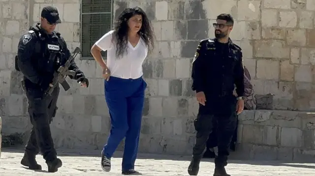 Шаррен Хаскел в сопровождении двух полицейских