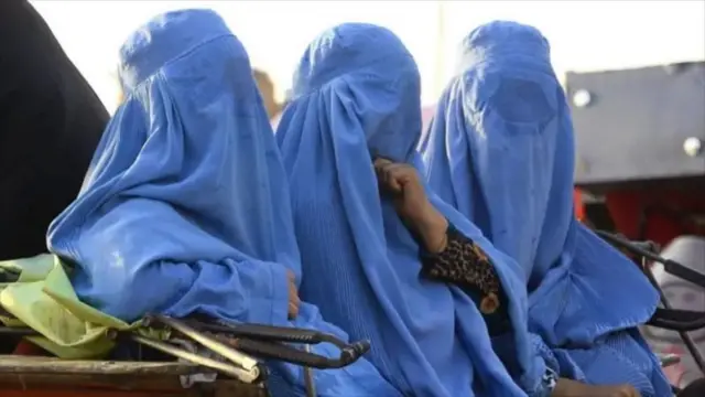 مېرمنې په څادرۍ کې لیدل کېږي.