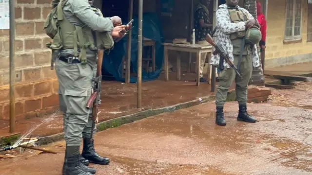 Deux militaires armés se tiennent devant une étale dans un quartier de Bamenda.