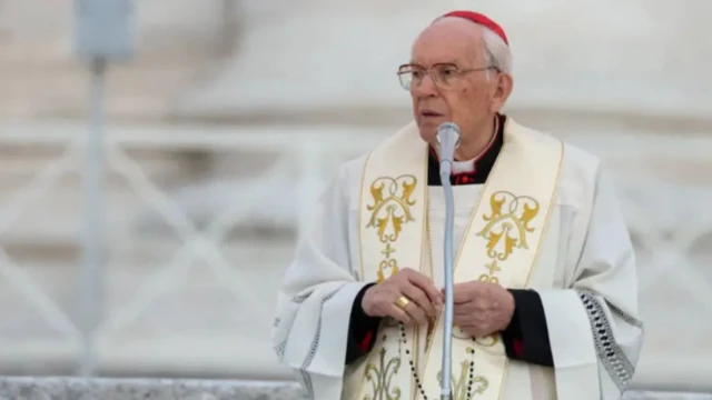 A cardinal wit red cap on his head, wearing a white robe