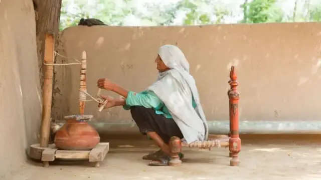 ਦੁੱਧ ਰਿੜਕਦੀ ਬਜ਼ੁਰਗ ਔਰਤ