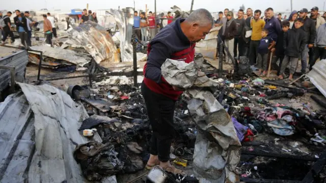 Um homem parado nos escombrosjogo de futebol que paga dinheiroum prédio destruído