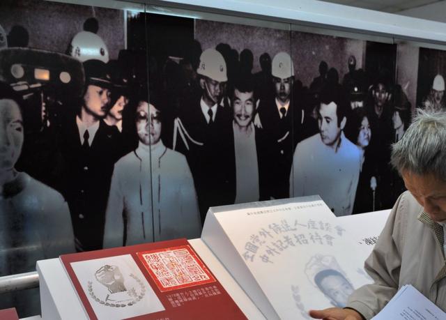This photo taken on December 8, 2009 shows a visitor (R) reading documents in front of images showing Taiwan dissidents on trial in 1979, at the Jinmei Human Rights Park in Hsintien in Taipei county. Thirty years ago a group of Taiwanese opposition activists staged what was meant to be a peaceful human rights protest, but it proved to be a turning point in ending one-party rule on the island. The Kaohsiung demonstration on December 10, 1979, which unofficial estimates said involved between 10,000 and 30,000 people, was intended as a peaceful call for human rights, but dozens were injured when protesters clashed with police