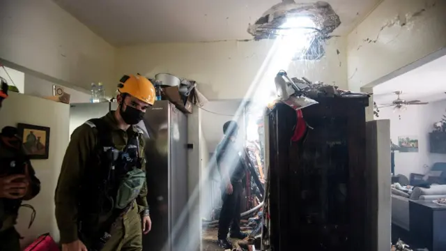 Soldiers work at a building damaged by a rocket launched from the Gaza Strip, in Ashdod, southern Israel, May 11, 2021.