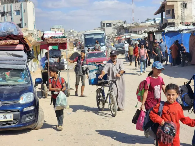 فلسطينيون يغادرون مع متعلقاتهم التي أمكن إحضارها معهم بعد هجوم الجيش الإسرائيلي على بلدة بني سهيلا في خان يونس بغزة في 7 أكتوبر/تشرين الأول 2024.