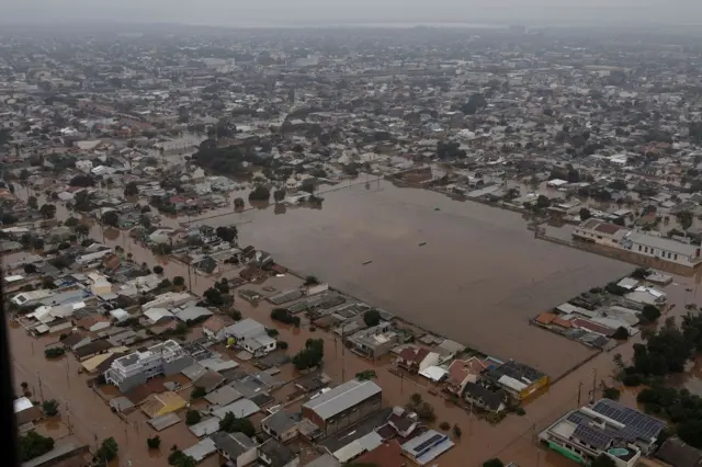 Foto aérea mostra casas e campo alagados, vistoscomo fazer bolao na loteria onlinecima