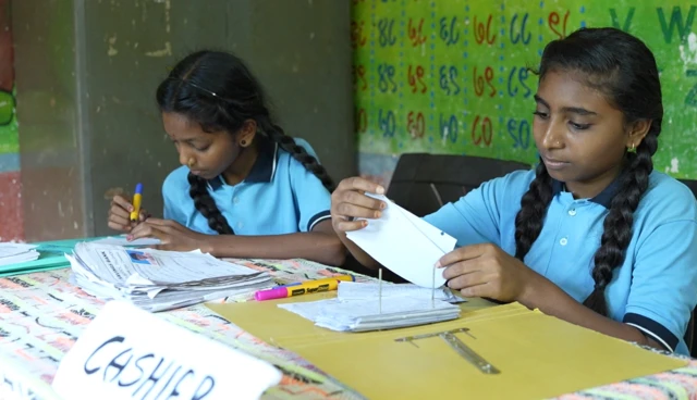 शाळेत विद्यार्थी एक बचत बँकही चालवतात