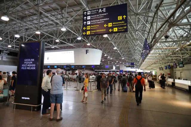 Pessoas em área de check in do aeroporto
