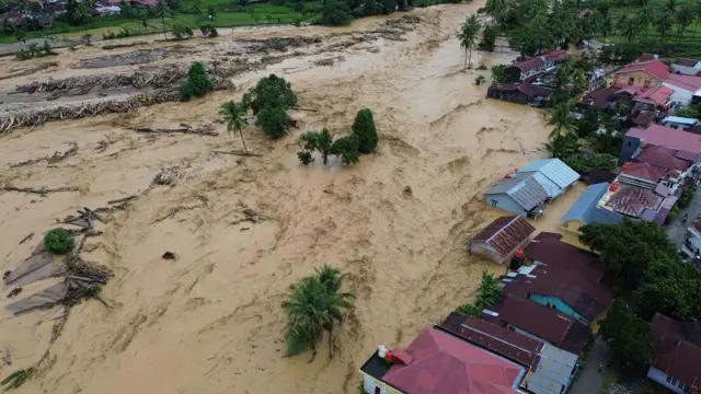 Foto udara sejumlah rumah diterjang banjir bandang di kawasan Gunung Nago, Padang, Sumatera Barat, Jumat (28/11/2025).