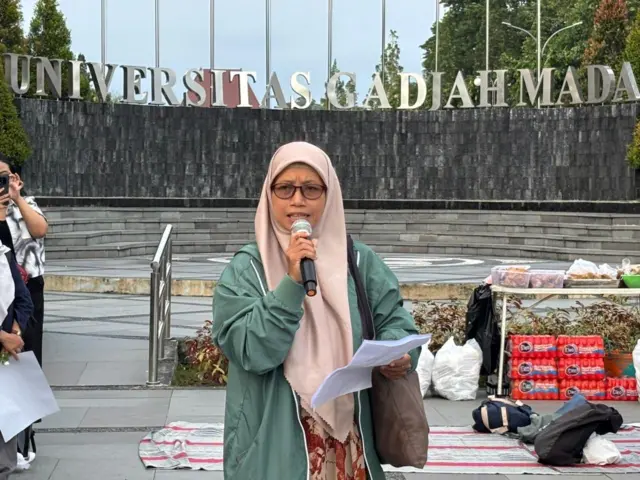 Wasingatu Zakiyah sedang memegang mikrophone dan membacakan pernyataan sikap di tengah Bundaran UGM.