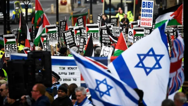 Personas con banderas de Israel y carteles en en contra de este país y a favor de Palestina en Londres.