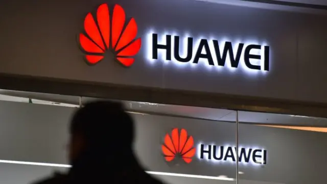 Un hombre caminando solo cerca de una tienda de Huawei.
