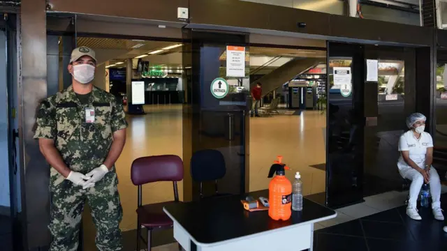 Um militar e uma enfermeira no portão do aeroportoaposte futebolLuque, pertoaposte futebolAssunção, no Paraguai