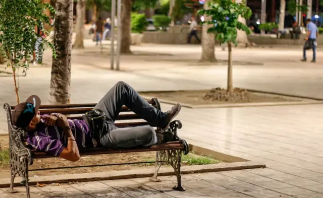 Un hombre duerme en un banco tras cruzar el Puente Internacional Simón Bolívar.