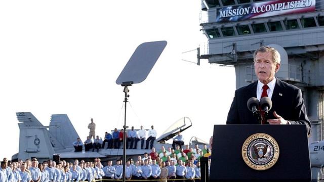 2003年5月、「任務完了」と書かれた横断幕の下で演説するブッシュ大統領（当時）