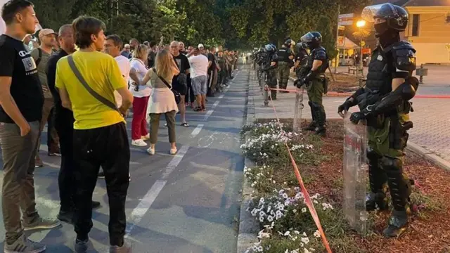 Колона људи са једне и жандармерија са друге стране