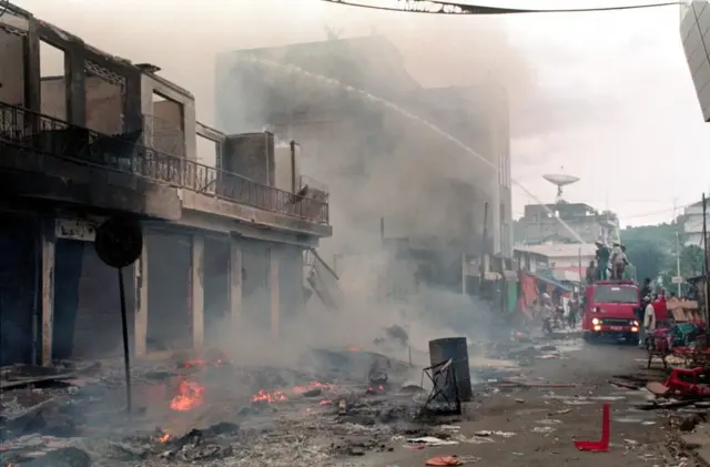 Petugas pemadam kebakaran berupaya memadamkan bangunan yang terbakar dalam kerusuhan di Ambon pada 20 Januari 1999.