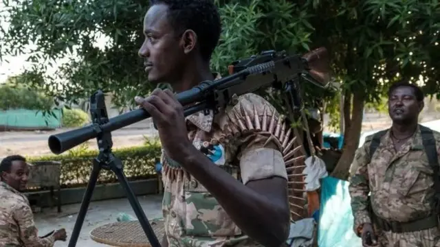 Umwe mu ngabo zidasanzwe za Amhara afise inkoho ya mitrailleuse (machine gun) ku kirindiro c’ikambi imbere ya butike, Ethiopia, ku wa 22 Munyonyo, 2020
