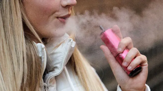 Close em moça fumando vape