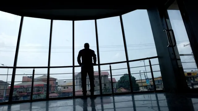 Chikodi dey look outside from inside one house