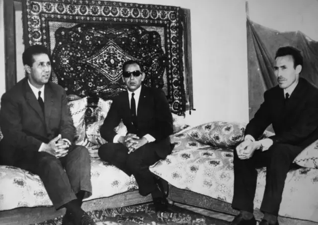 لقاء بين الرئيس الجزائري أحمد بن بلة والملك الحسن الثاني ملك المغرب، وعلى اليمين وزير الدفاع الجزائري هواري بومدين في صورة يعود تاريخها لـ 16 مايو 1965