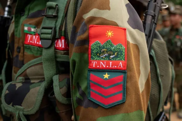 TNLA စစ်ယူနီဖောင်းရဲ့ လက်မောင်း ဘက်တံဆိပ် (ပုံဟောင်း)