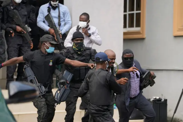Armed DSS operatives cover dia faces mount for court