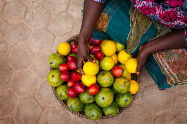 Umugore ufite imbuto zirimo n'imyembe n'amacunga