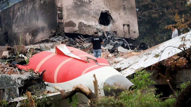 2025年6月13日，在印度艾哈邁達巴德，一名消防員站在墜毀的印度航空波音787-8夢幻客機旁