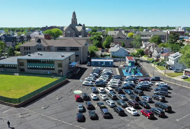 An aerial view of a large group of cars outside the Parish of Saint Agnes Cathedral