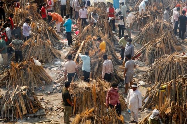 People prepare funeral pyres of those who died from the coronavirus disease (COVID-19), during a mass cremation, at a crematorium in New Delhi, India April 26, 2021