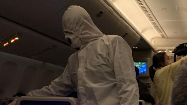飞机上替乘客测量体温的空乘人员