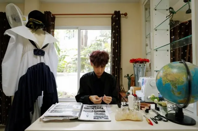 ติณห์ ตันโสภณ นั่งที่โต๊ะ